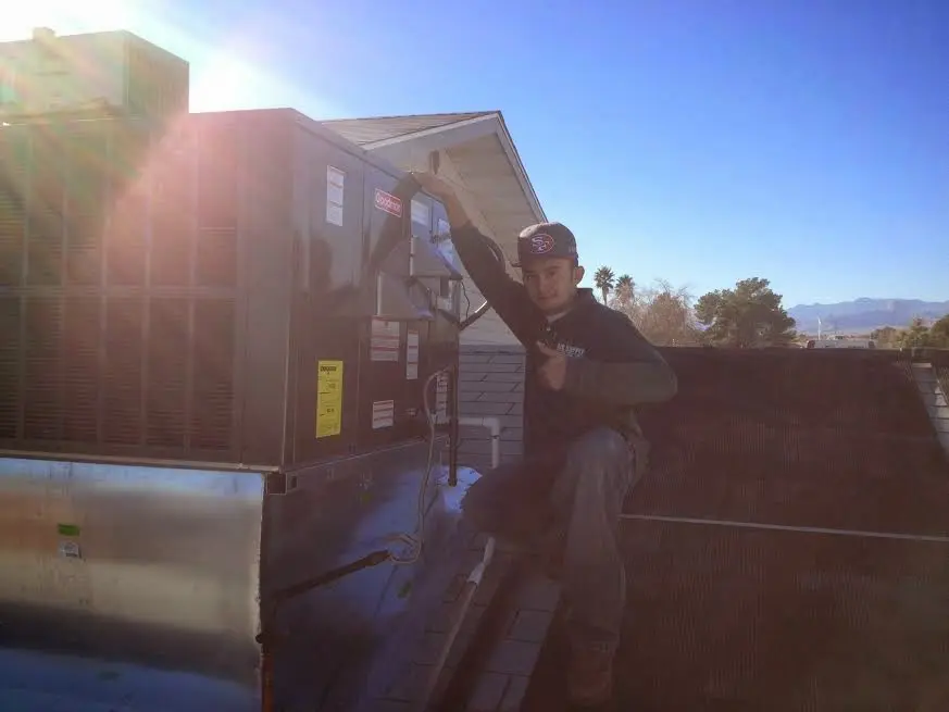 HVAC technician performing AC Tune-Up on a rooftop unit in Pomfret